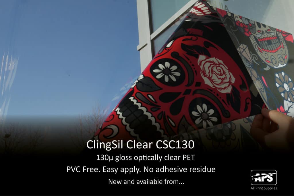 A photograph of a ClingSil Clear self-adhesive graphic being pulled away at the corner from an exterior window that it has been applied to. The image is of skulls and roses with a Mexican day of the dead type theme, in red and black colours with the addition of white ink that highlights the skull shapes on the clear, see-thru vinyl.