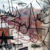 Anti-Graffiti protection laminate, AGU-30, adds protection to prints from tagging and vandalism damage. Image shows graffiti on a clear window which can be easily cleaned away with proper cleaning agents, due to the properties of this graphics protection film.