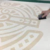 Applying graphics transfer paper, RTape Conform 4075 RLA, over an intricate cut-vinyl design in preparation for transferring the self-adhesive sign vinyl image onto the final substrate.
