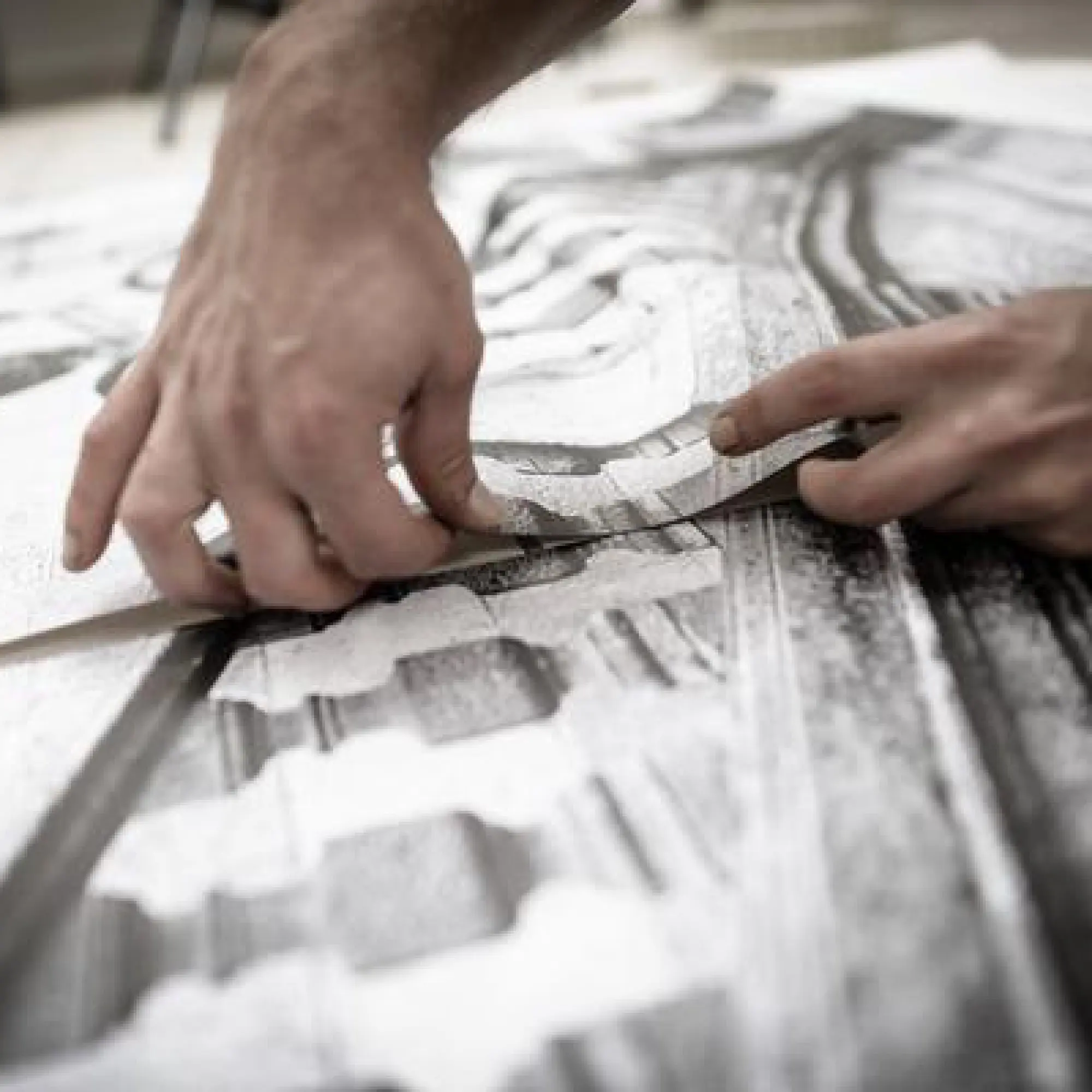 A close-up on a pair of hands as they apply the UV dot print n walk textured floor print film.