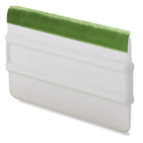 Green velvet self-adhesive replacement squeegee edge strip for vinyl wrapping tools stuck to the edge of a white ribbed applicator tool.