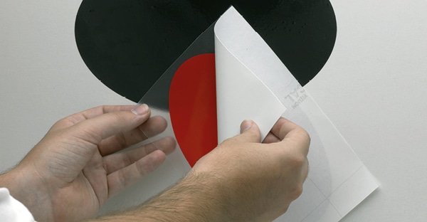 KleenView Clear graphics transfer application film being held prior to transfering an adhesive graphic, with the white liner being peeled away.