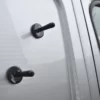 Two vehicle wrapping magnets are randomly attached on the side of a van prior to offering up a large wrap vinyl to hold it in position before removing the liner and fixing the adhesive side to the substrate.