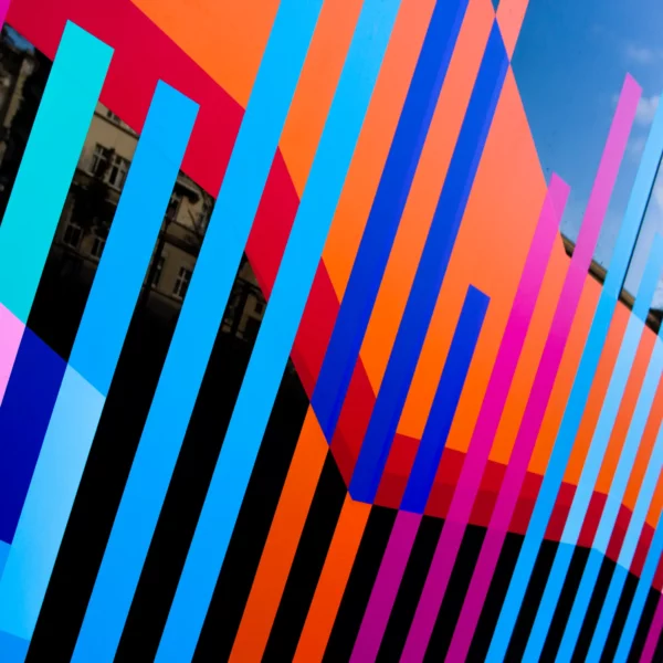 A close-up on self-adhesive vinyl that has been cut into different coloured stripes and positioned into vertical patterns. Created using Avery 200 PF sign vinyl the stripes and colour blocks have been creatively applied to an exterior window for decorative display and signage purposes at a public library.