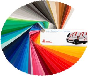 Avery Dennison 777 Performance Film cast colour sign vinyls swatch with the pages fanned out showing the full spectrum of vinyl colours in the sample pages, with AD branded cover of CAD-CUT '777' conformable signage lettering applied to a van.