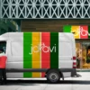 Avery 800 PC cast sign vinyls shown here used to create colourful cut-vinyl vehicle branding in bright green, golden yellow, mid-red and dark green, that has been applied to the sides of a white van which is parked outside retail premesis which share matching coloured retail signage above the shop entrance.