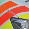 Close-up detail of the 3 gloss fluorescent colours from Avery Dennison's 900 Series applied as cut-vinyl decals to the side of a van for visual punch as a part of the vehicle livery branding.