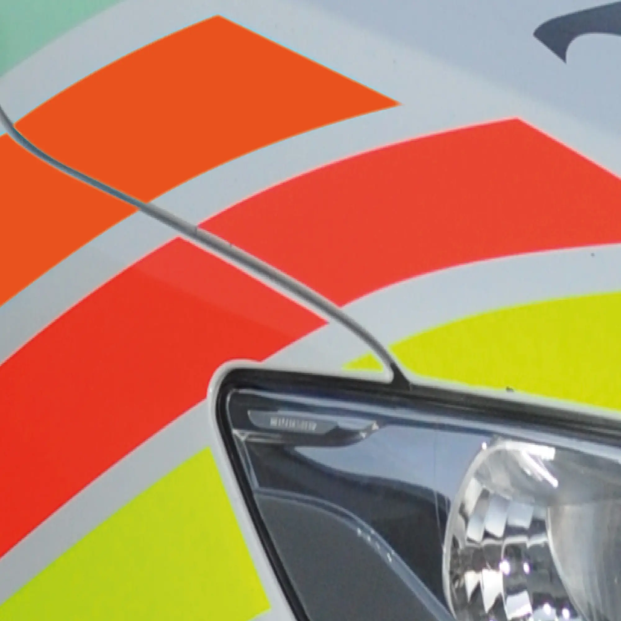 Close-up detail of the 3 gloss fluorescent colours from Avery Dennison's 900 Series applied as cut-vinyl decals to the side of a van for visual punch as a part of the vehicle livery branding.
