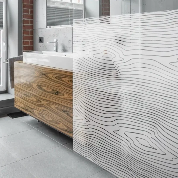 Avery Crystal self-adhesive etch effect window vinyl applied as a privacy divider screen in this washroom onto a perspex screen with a cut-vinyl wood ring pattern design.