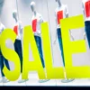 Avery Dennison 900 Fluorescent Yellow coloured cut-vinyl 'SALE' lettering applied to a clothing retailers window, advertising promotions in-store, with manaquin dummies posed in constrating, eye-catching coloured garments in the large display window behind the graphic.