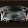 Two people stretch out a clear SPF film to cover the whole bonnet on a wide vehicle, the film is XL wide and wide enough to cover the hood with no need for seams / joins.
