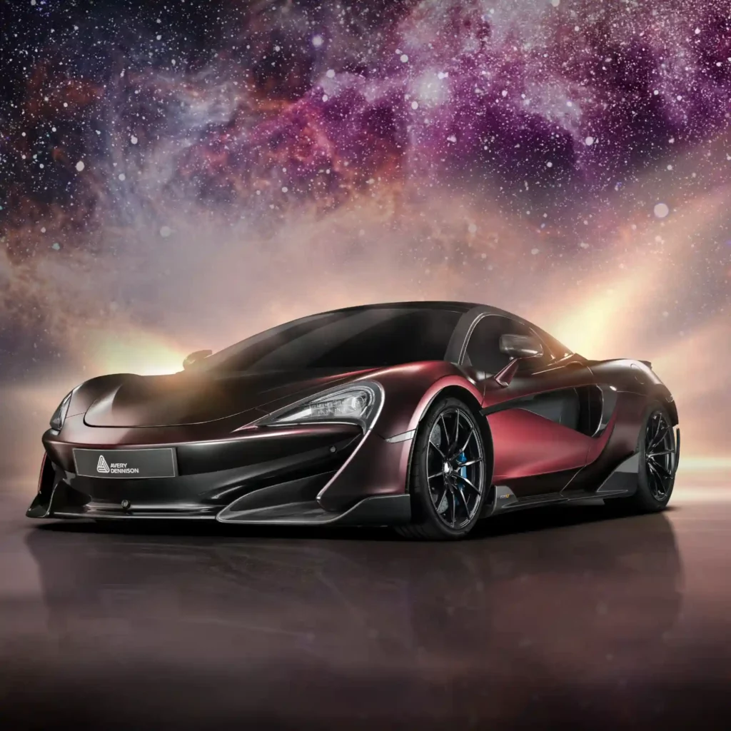 Avery Dennison's Supreme Wrapping Films range of conformable cast coloured vinyls offers a complete galaxy of coloured films and different finishes to wrap vehicles... or any object requiring a longer term lifespan! This image shows a wrapped burgundy metallic sportscar with a Galaxy of stars and space nebula in the background in complementary dark red and burgundy shades.