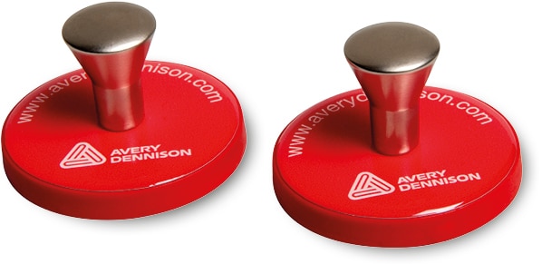 Two red coloured magnets with finger grip handles - for easily holding large sheets of vinyl in position while applying self-adhesive graphics onto vehicle bodies.