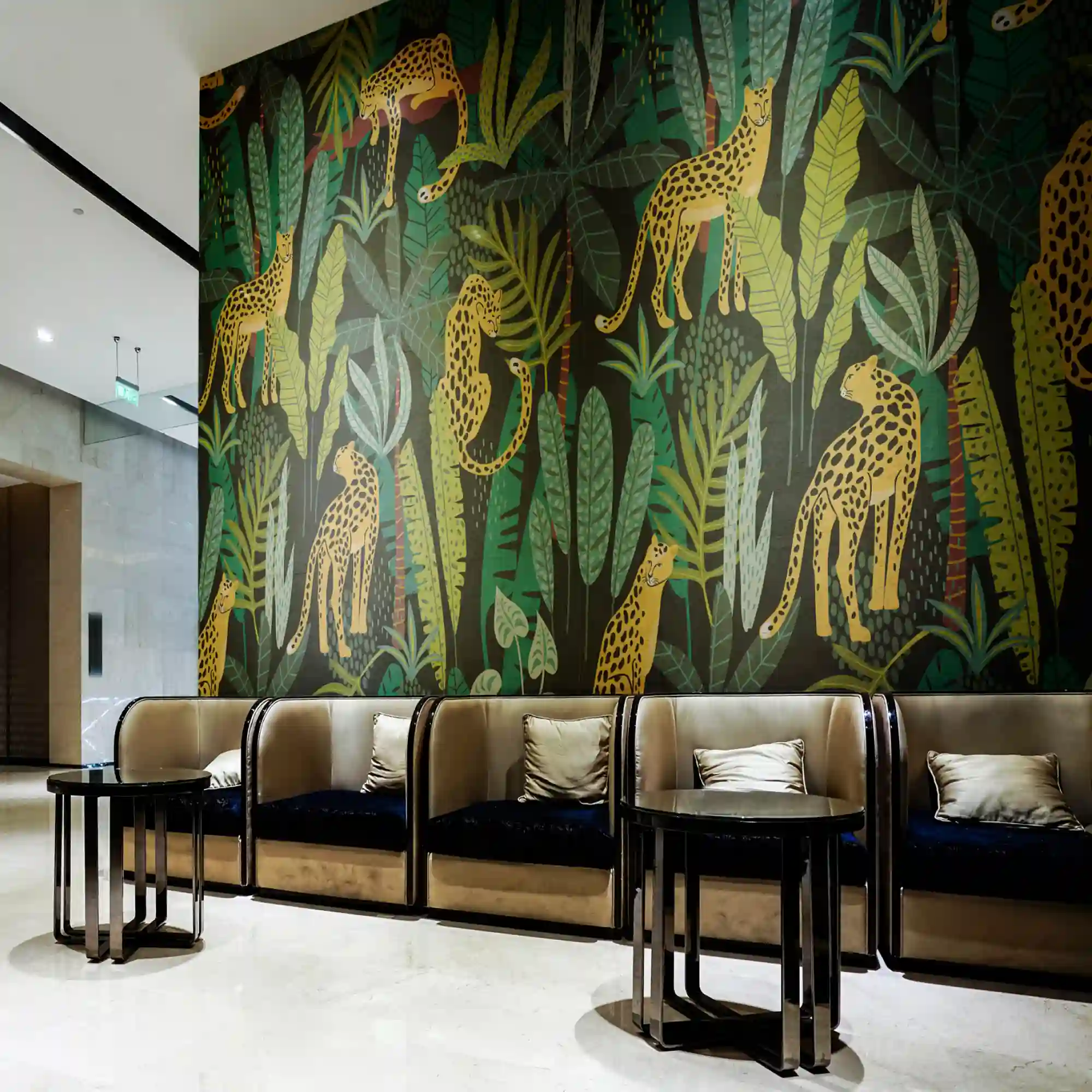 Avery Dennison MPI 8626 wall print vinyl featuring a bold, printed graphic of leopards in a jungle, applied to a lobby wall. Impactful wallpaper art prints like this bring bespoke, vibrant, exotic flair to commercial and hospitality interiors.