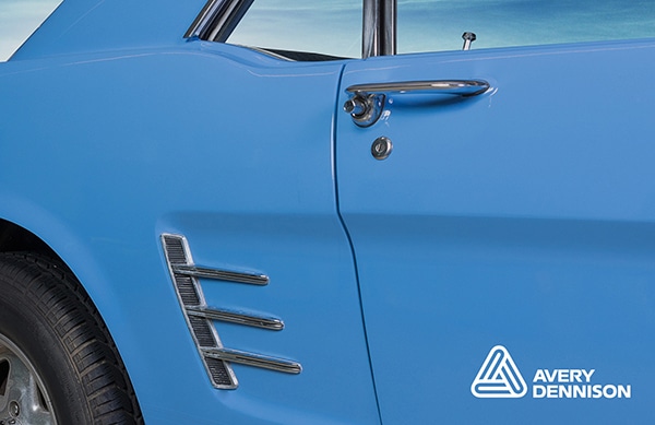 Avery Dennisons' Supreme Wrap 'Smokey-Blue' solid coloured vinyl applied to an elegantly lined, classic car - the photo is a close up of the side profile of this beautifully shaped vehicle.