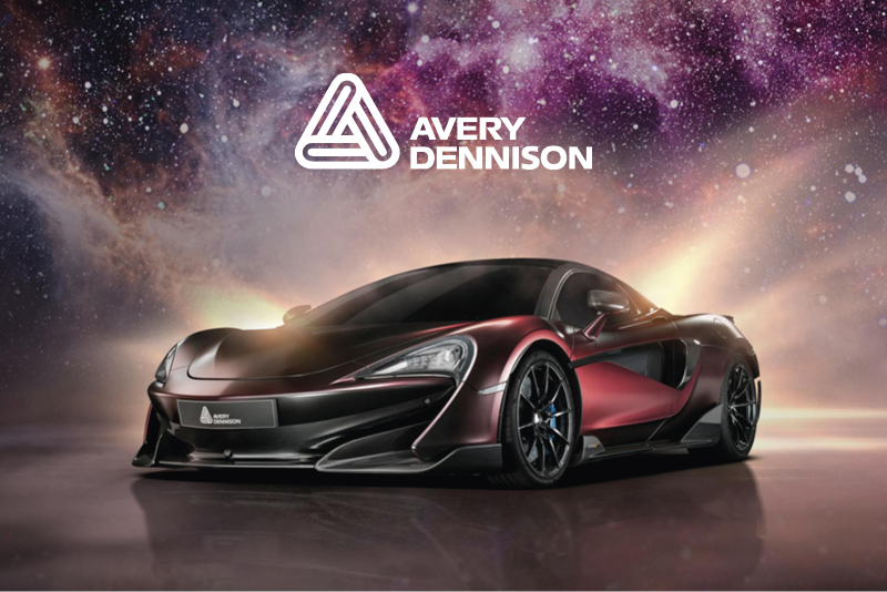 Avery Dennison Supreme Wrapping Film, deep red satin vinyl on a sports car with a galxy of stars behind the car in moody complimentary red and purple hues.