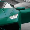 Silky-looking Pearlescent colours from the Avery Dennison Supreme Wrapping Films range of self-adhesive vinyls add a touch of class and a unique Pearl Dark Green coloured finish to the sleek contours of a sports car, with the image focussing on the opened door, wing mirror, bonnet, headlight and radiator grill, viewed from the front.