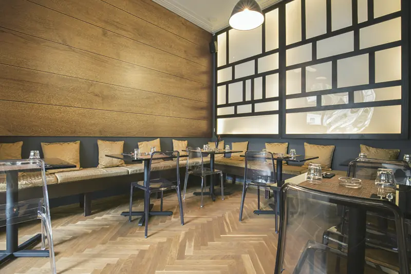 Big Wood textured oak finishes cover the walls and tables in this restaurant with solid colour black interior vinyl used to wrap the window frames and wooden benches completing the well designed choice of colours and finishes.