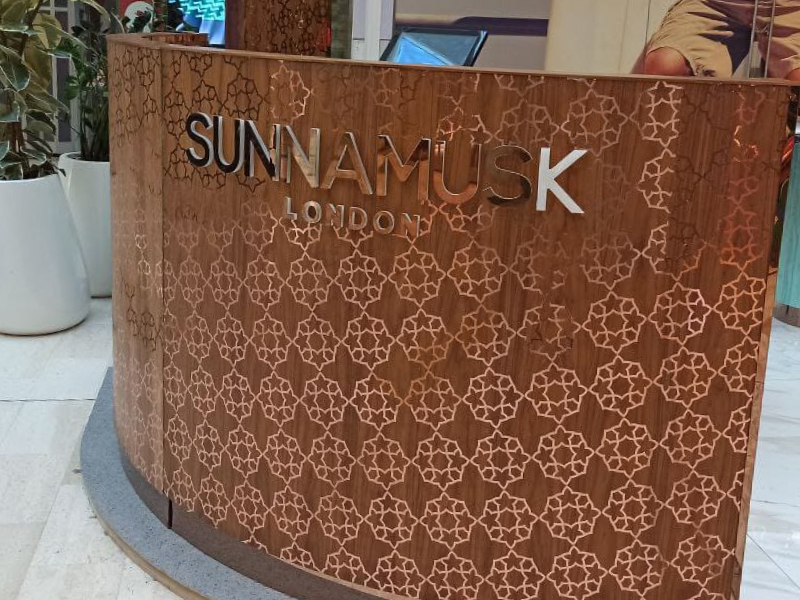 T72-P-P Rose Gold metallised sign vinyl intricate cutout pattern decorating outside of a retail counter desk.