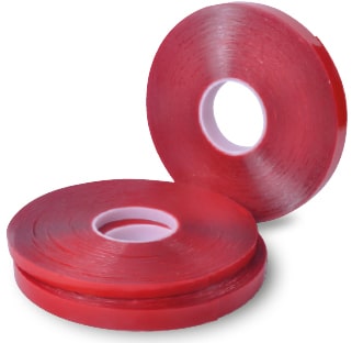 Clear double-sided ultra high bond sign tape, UHB-C-10F, shown in reeled rolls in the three different sizes, two of the reel widths are on their side, horizontally stacked on top of each other, and the third reel is offset to the side standing upright on it's short edge.