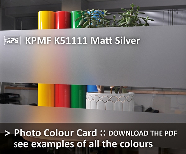 KPMF K51111 Matt Silver glass etch window film is shown installed onto an internal office window with a selection of coloured objects behind the window vinyl to show the colour, light transmission and privacy this coloured film provides - Download the photo colour card PDF to see all colour examples of the window decoration films in this range.