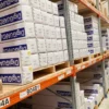 High-performance DigiGuard GU3-70 ultra-gloss laminate for outdoor digital prints and self-adhesive graphic signage, in branded packaging, stacked neatly in All Print Supplies Ltd large warehouse in Slough, UK.