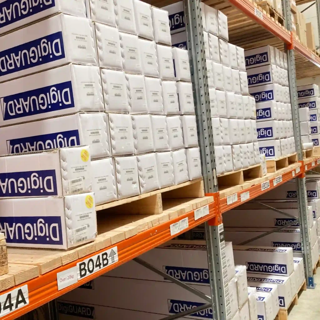 High-performance DigiGuard GU3-70 ultra-gloss laminate for outdoor digital prints and self-adhesive graphic signage, in branded packaging, stacked neatly in All Print Supplies Ltd large warehouse in Slough, UK.