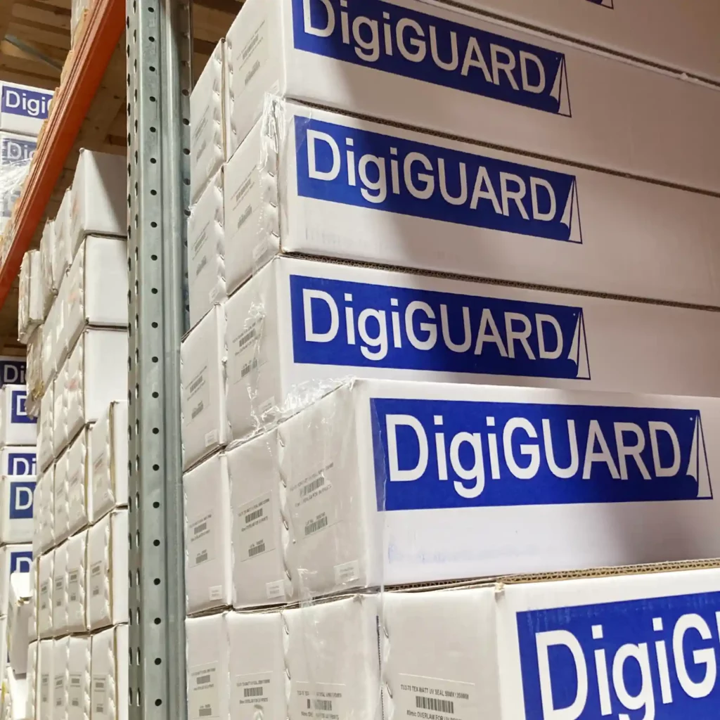 Matt finish UV inks laminate, DigiGuard MU4, for the protection of self-adhesive signage and digitally printed graphics is shown in neatly stacked packaging across multiple shelving levels awaiting call-off by graphics finishing professionals.