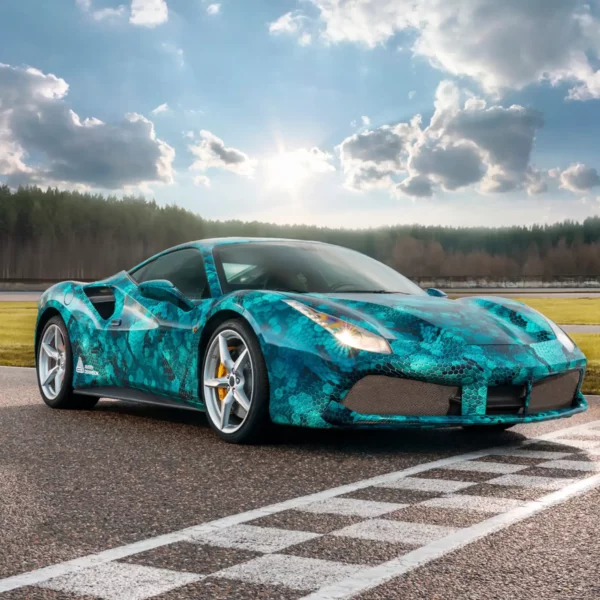 DOL 1460 Z Gloss car wrapping laminate protecting the printed self-adhesive film that features a geometric shaped, blue snakeskin style design that has been applied to a highly contoured sportscar which sits on a race track start line.