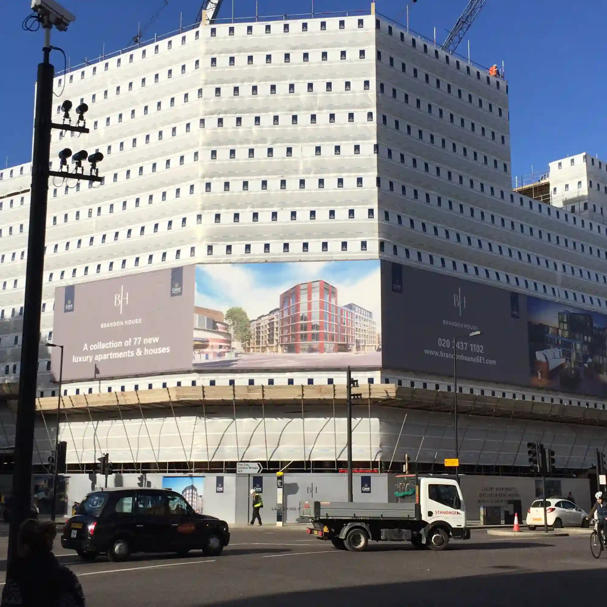 EF440 print branded scaffold wrap construction banner attached to the side of a large city development with the dual-purpose of offering high-impact outdoor advertising on building sites as well as well as to shield the public from unsightly scafolding and construction works that are in progress.