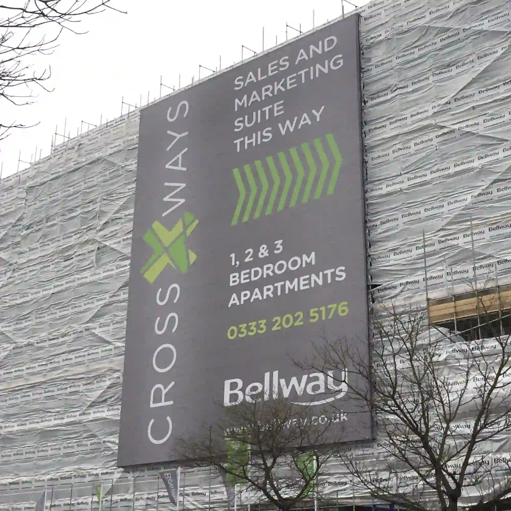 EF500 ultra-large format printed construction site banner attached to the side of a large city development site, offering the dual-purpose opportunity for high-impact outdoor advertising and to shield the public from unsightly scaffolding and other on-site works that are in progress.