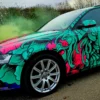 Fedrigoni C50 Ultimate vehicle wrapping print film fully wrapped onto this Audi car in a brightly printed fish and fauna red, purple and green with black outlines design, showing close-up on the front detail of the car contours, around wheel trims, headlights and wing mirror.