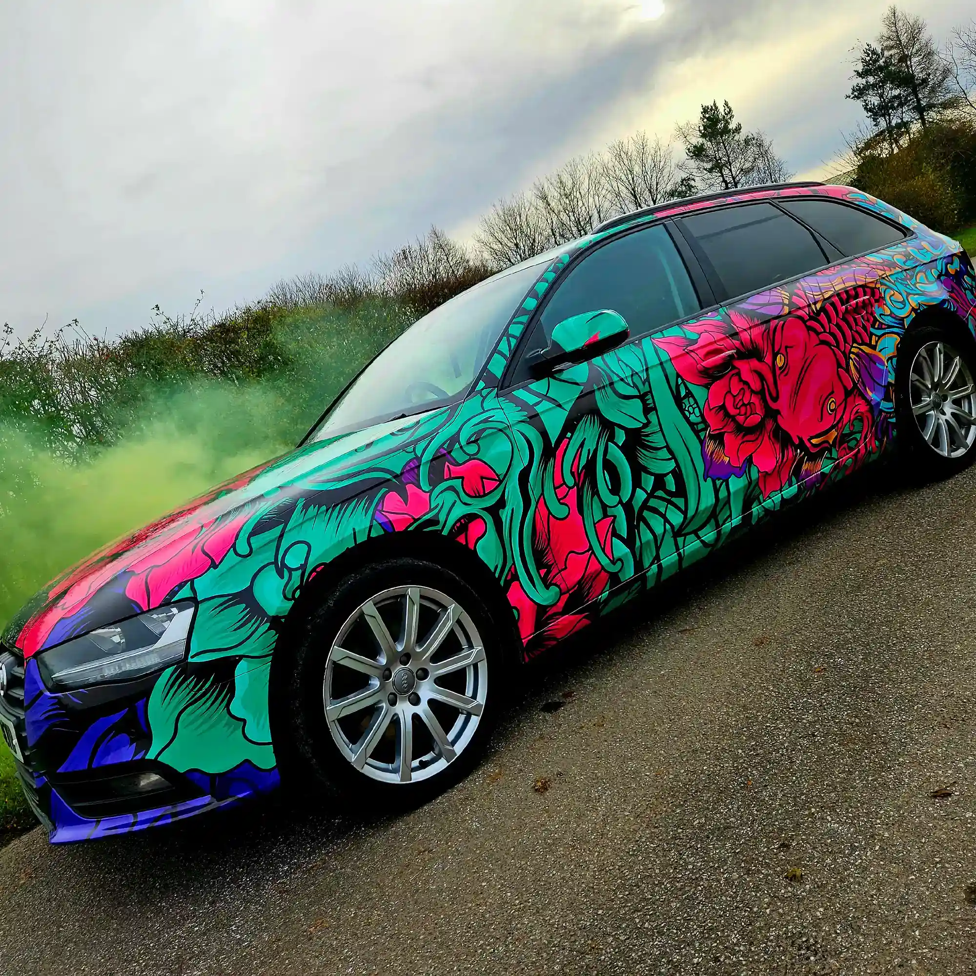 Fedrigoni C50 Ultimate vehicle wrap print film with C30 Ultra Gloss wrap laminate, fully wrapped onto this Audi car in a brightly printed fish and fauna red, purple and green with black outlines design.