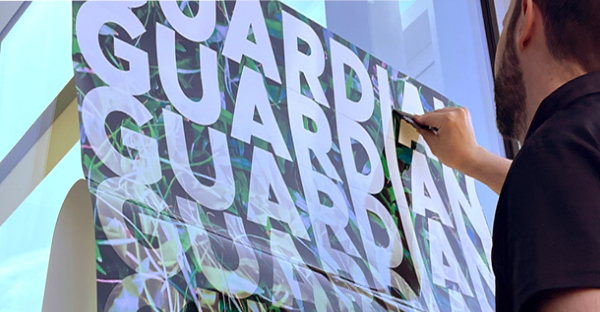 Guradian Lam Gloss non-PVC laminate for digital inks being applied to a window with an application squeegee used for self-adhesive printed graphics.