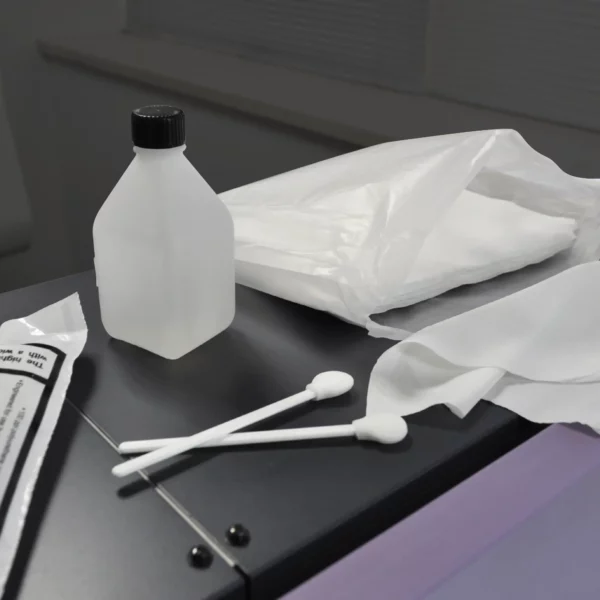 Inkjet printer maintenance products, from left to right lined up on a wide-format digital ink printer: Head Cleaning Fluid bottle, Cleaning Swabs and white Lint Free Cloths.