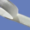 A photo close-up of the white strips of both 'hook' and 'loop' tape being stuck together to show the two different shapes in the tapes more clearly... the 'hook' side is on top and the 'loop' side underneath.