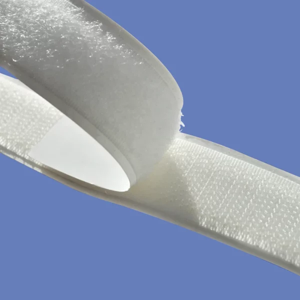 A photo close-up of the white strips of both 'hook' and 'loop' tape being stuck together to show the two different shapes in the tapes more clearly... the 'hook' side is on top and the 'loop' side underneath.