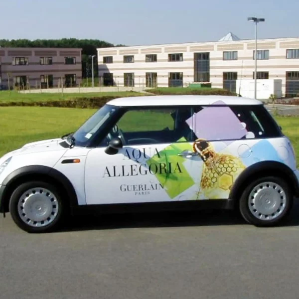 Mactac's JT 9500 WG-PT glosss white polymeric print film applied as a partial graphic onto the side of a mini car that is advertising perfume.