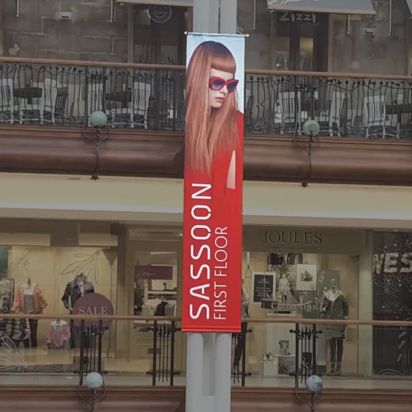 KREA Blackbak Soft 1056-16 printable fabric used to produce this frontlit banner display advertising within a shopping precinct setting for a large format hanging banner hairdresser advert.