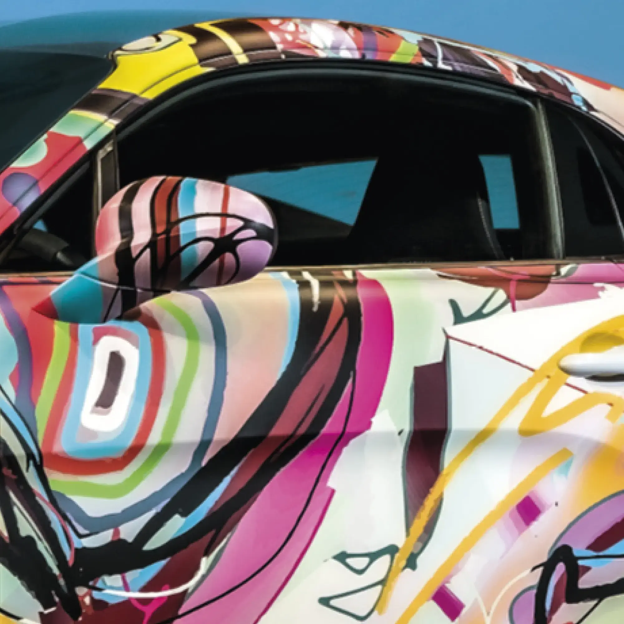 LF 10700 CM-UV matt vehicle wrapping laminate and abstract art style printed vinyl is fully covering all the curves of this cars contours with the focus on the trims conformed around the door, handles and wing mirror.