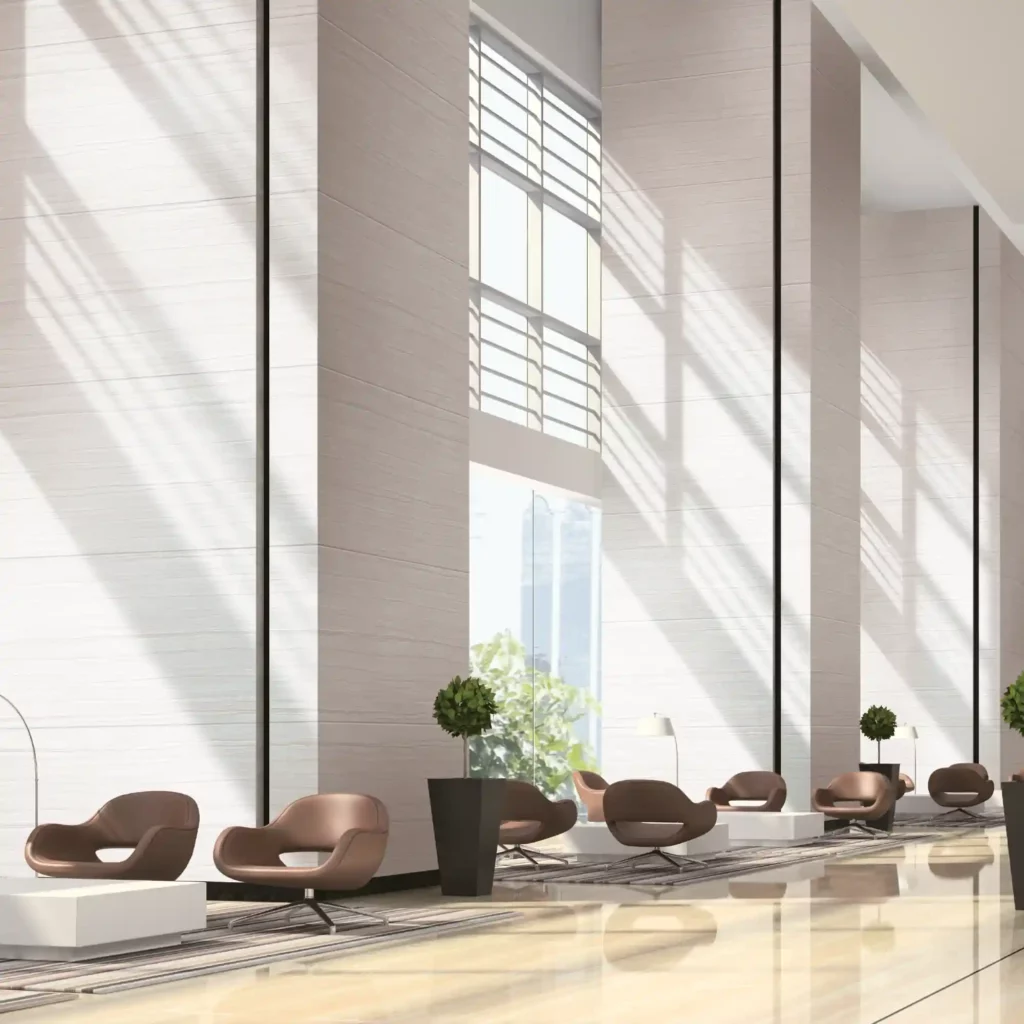 LX Hausys BENIF self-adhesive interior films will also cover walls and are available in a huge choice of different colours, textures and special finishes. These decorative vinyls bring new life and a quick change of style to any room, like this high ceiling reception area with large high windows that are complimented by the finish of the light colour and delicate stone texture of the vinyl wrapped walls.