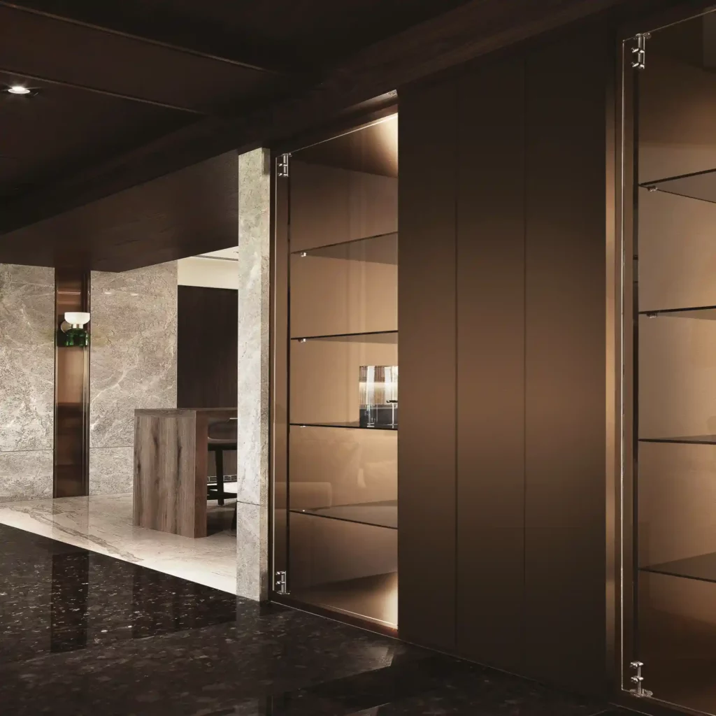 LX 'Textured Metal' interior film finishes totally transform the fixed furniture within this open living room area with a stylish dark copper colour that is beautifully lit from within and surrounding the glass shelving that is hosued within the wall alcoves.