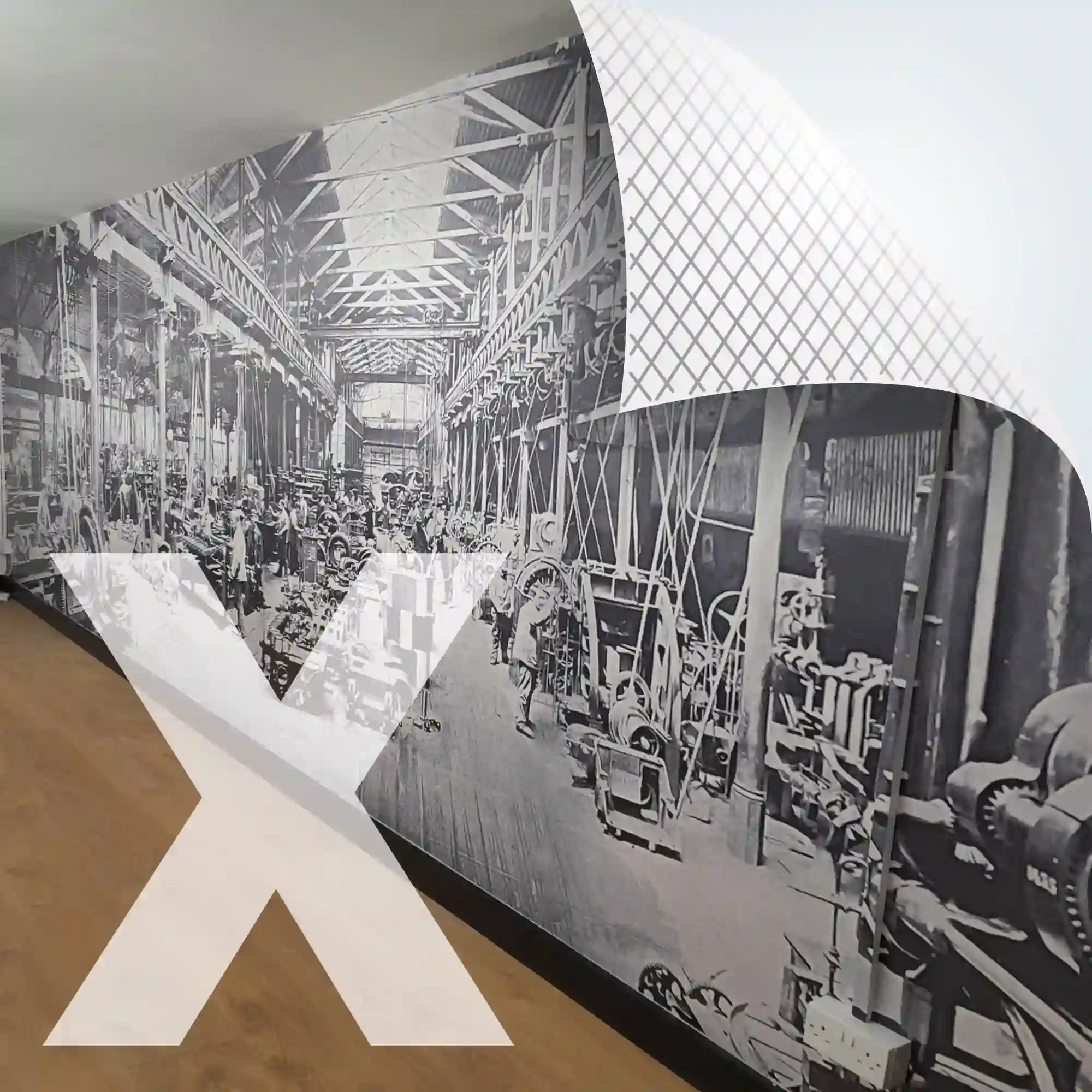 NU-COAT M12-H high opacity, cover all, print vinyl with a high grab airXit (bubble-free) adhesive is applied here to an interior office wall with a large format print of a black & white historical photograph of a machine factory floor from a bygone era, with belt driven power. This self-adhesive graphic film is perfect for wall applications due to the extra strength of the adhesive that will stick to difficult surfaces.
