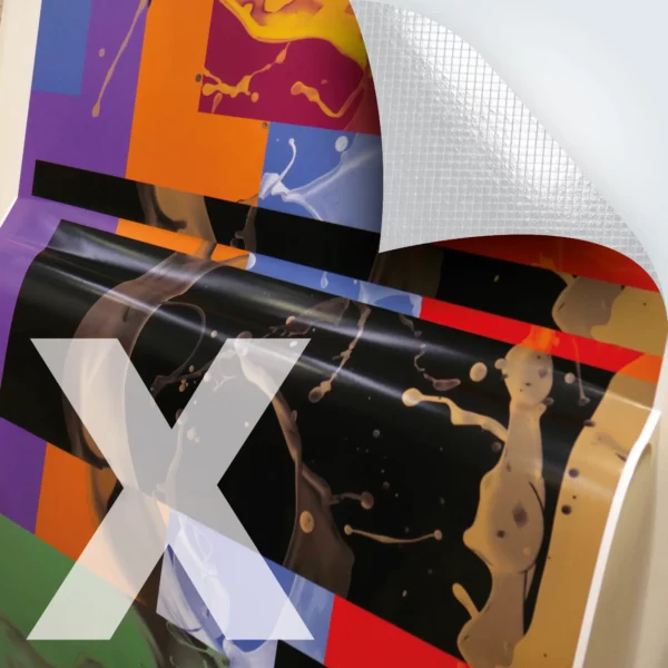 M15-P-X matt white self-adhesive print vinyl with air-release, bubble-free graphics adhesive has been printed with a colourful, decorative abstract design that is half-applied to a flat surface with the airXit liner hanging down away from the adhesive side of the film but remaining attached at the bottom of the film prior to being completely removed and fully stuck into position on the substrate. The top right corner of the picture includes a superimposed graphic with a folded down corner and cross-hatched lines that depict the embossed air release liner characteristic of this monomeric graphics film.