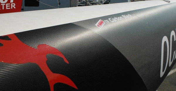 Textured Carbon Fibe Satin Black wrap film conformed all over the hull of a boat wrap design.