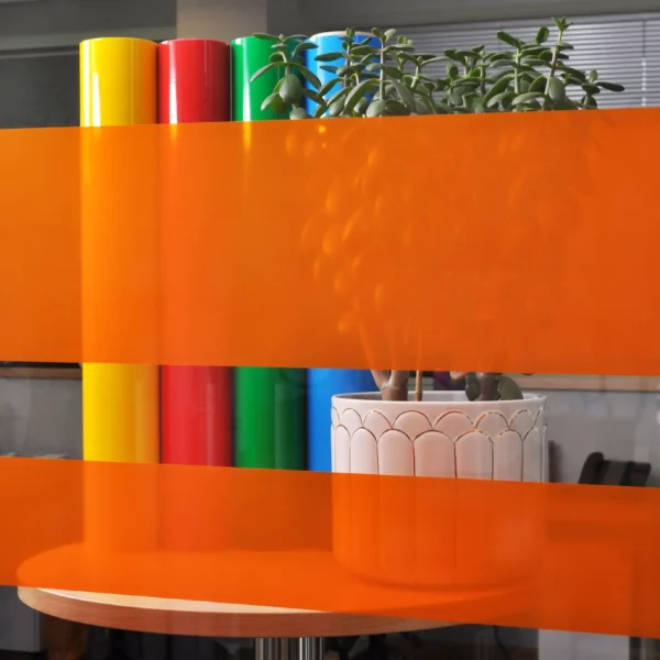 MACcrystal 8407-03 Orange tinted transparent window vinyl sample applied to an internal office window to show the level of transparency and the decorative colour transformation effect that this tint coloured self-adhesive film provides.