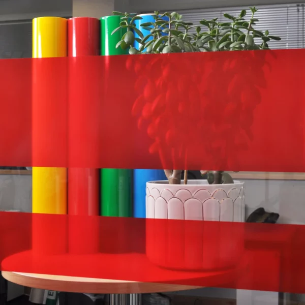 MACcrystal 8447-01 Deep Red coloured self-adhesive tint window film sample applied to an internal office window to show the level of transparency and the decorative colour transformation effect that this bright and transparent vinyl offers.