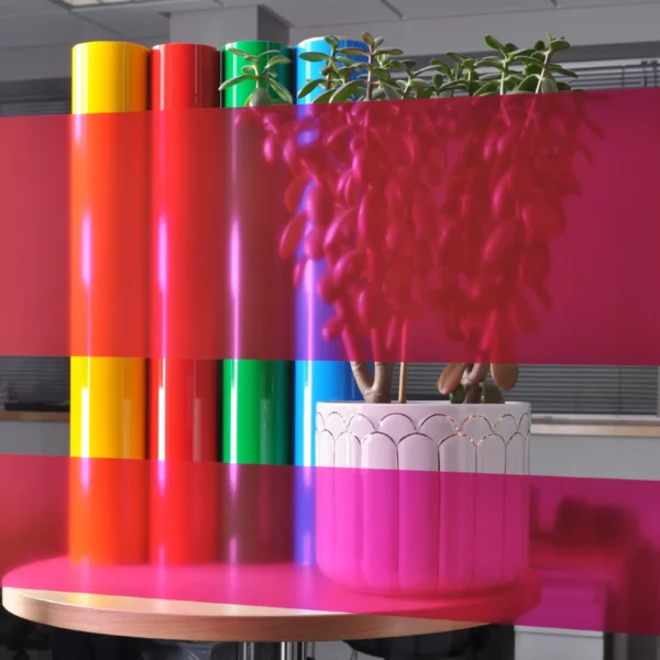 MACcrystal 8457-04 Fushia colour tint window film sample applied to an internal office window to show the level of transparency and the decorative colour transformation effect that this magenta/pink self-adhesive film offers.