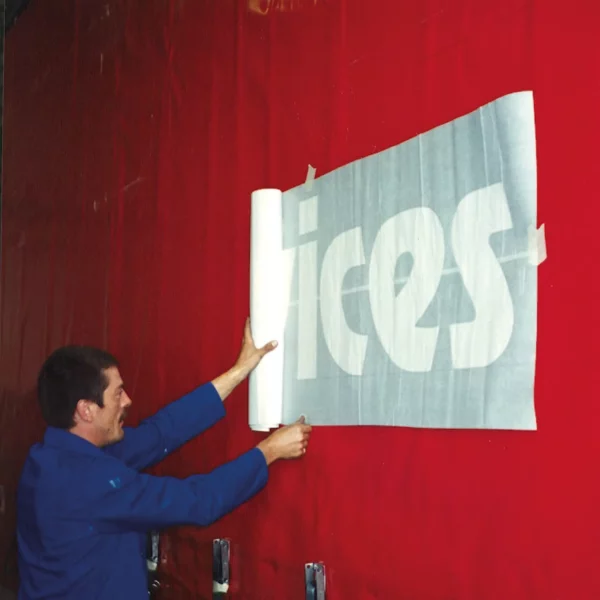 The stencil graphic has been weeded out and application tape applied on top to keep the stencil film in position during installation onto the graphics' surface.