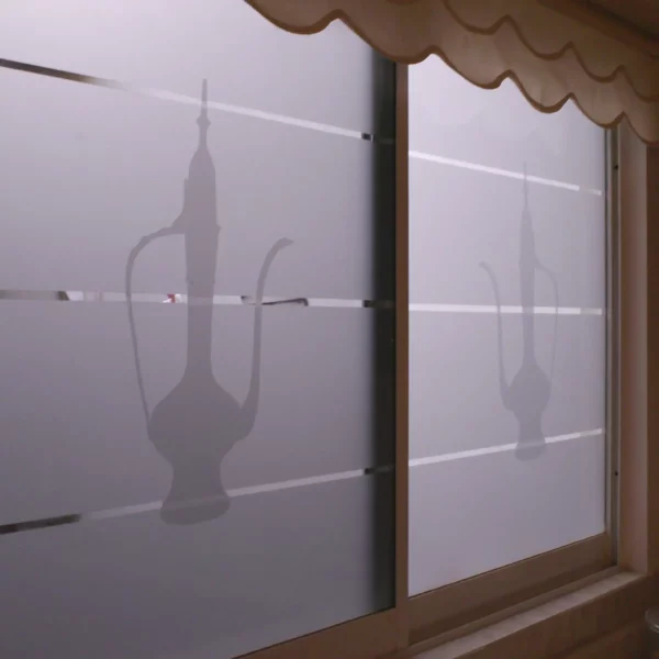 598-03 Frosted effect cut-vinyl window decoration in the shape of a tall, elegant styled coffee pot graphics, with 2 layers of the film applied one on top pf the other so thgat the full window is covered while the pot image appears darkened because there is twice as much film for the outside light to come through, providing decorative signage and window obscurity.